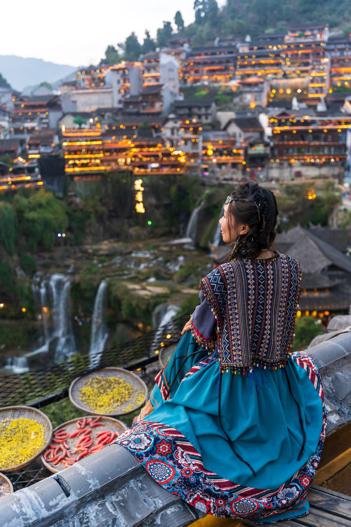 Mujer sentada contemplando la ciudad de China